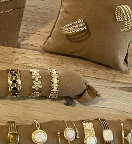 Bagues et bracelets dorés sur des coussins en suédine