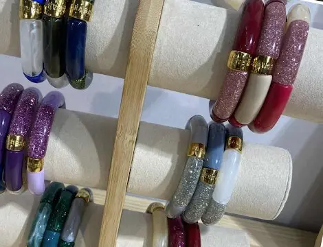 Bracelets jonc colorés et pailletés sur un présentoir